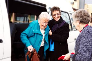 Carer with elderly woman getting out of van
