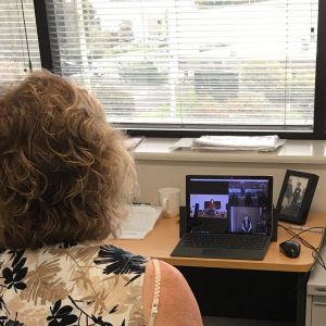 Woman in front of laptop with Mercy Health Wellness Centre online class in progress