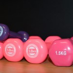 Two pink 1kg dumbbells, a 1.5kg dumbbell, and a purple 5kg dumbbell used at the Mercy Health Wellness Centre