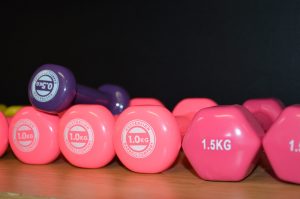 Two pink 1kg dumbbells, a 1.5kg dumbbell, and a purple 5kg dumbbell used at the Mercy Health Wellness Centre
