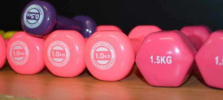Two pink 1kg dumbbells, a 1.5kg dumbbell, and a purple 5kg dumbbell used at the Mercy Health Wellness Centre