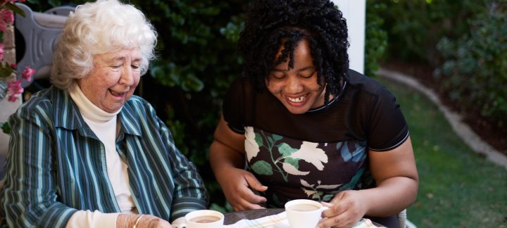 Female Home Care Package client enjoying a cup of tea and biscuits with her female home care worker