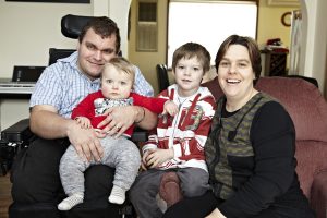 NDIS client, Zane McKenzie with his wife, young son, and baby son