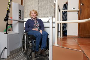 Woman shows off her elevator purchased through NDIS funding